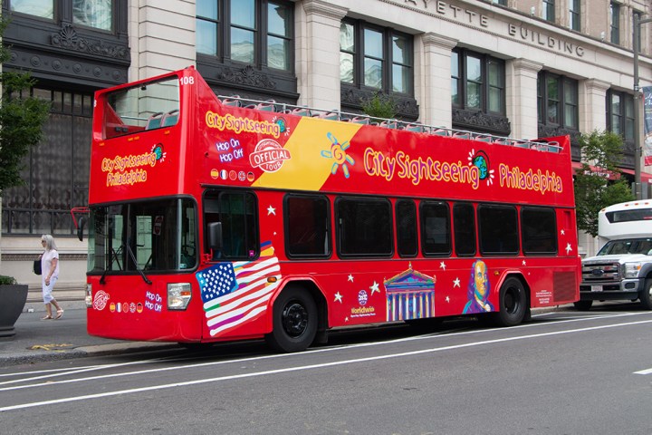 a red double decker bus driving down a street