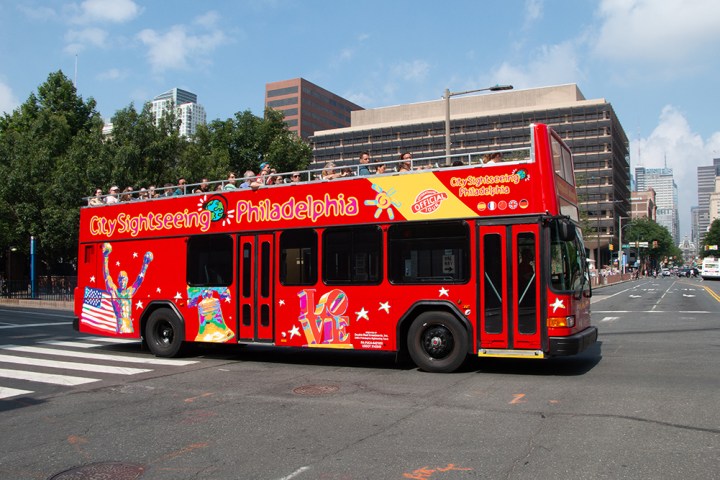a red tour bus driving down a street