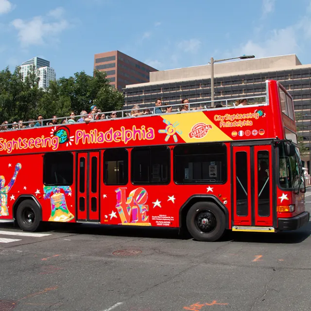 a red tour bus driving down a street
