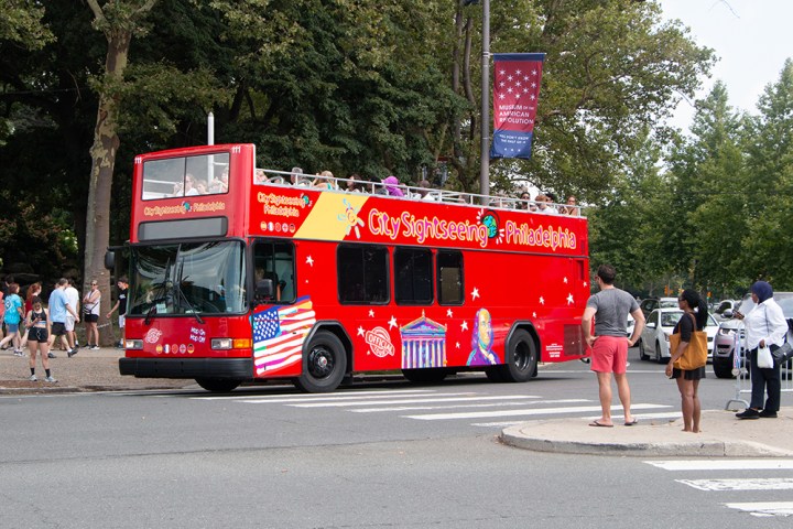 a red bus is parked on the side of a road