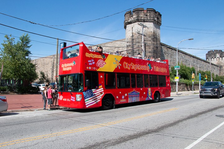 a red double decker bus parked on the side of a road