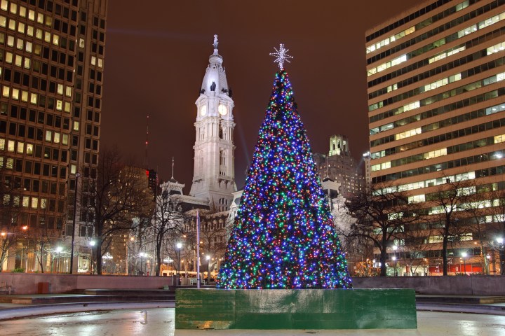 A Christmas tree in downtown Philadelphia lit up at night.
