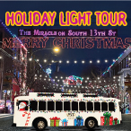 Holiday-themed bus on decorated street with festive lights and signs.