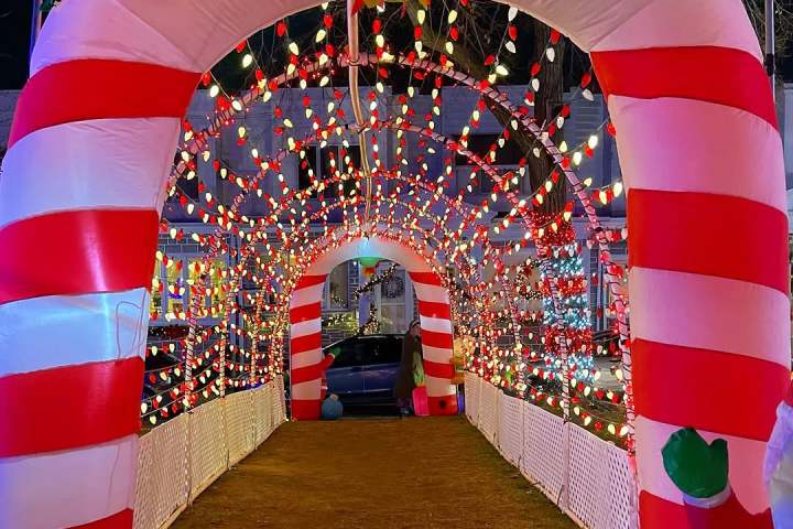 Festive archway with red and white lights, resembling candy canes.